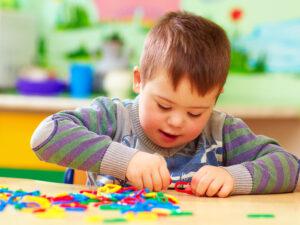 Cute,Kid,With,Down's,Syndrome,Playing,In,Kindergarten 3